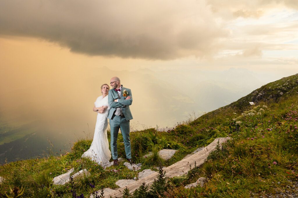 Hochzeitspaar in den Alpen bei dramatischem Himmel, Schweiz