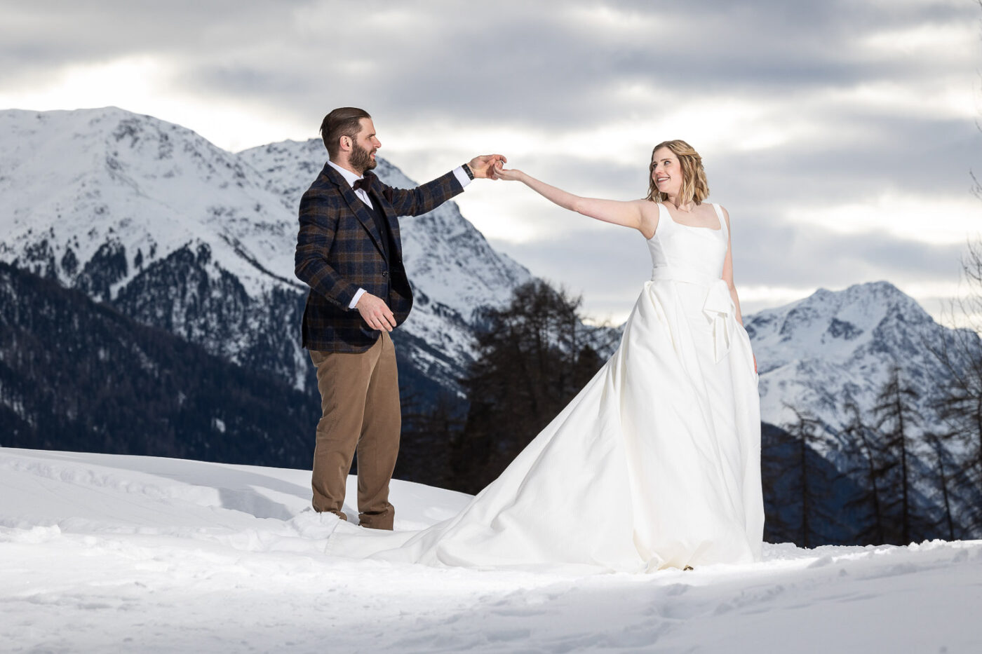 Hochzeitspaar im Schnee vor majestätischer Berglandschaft