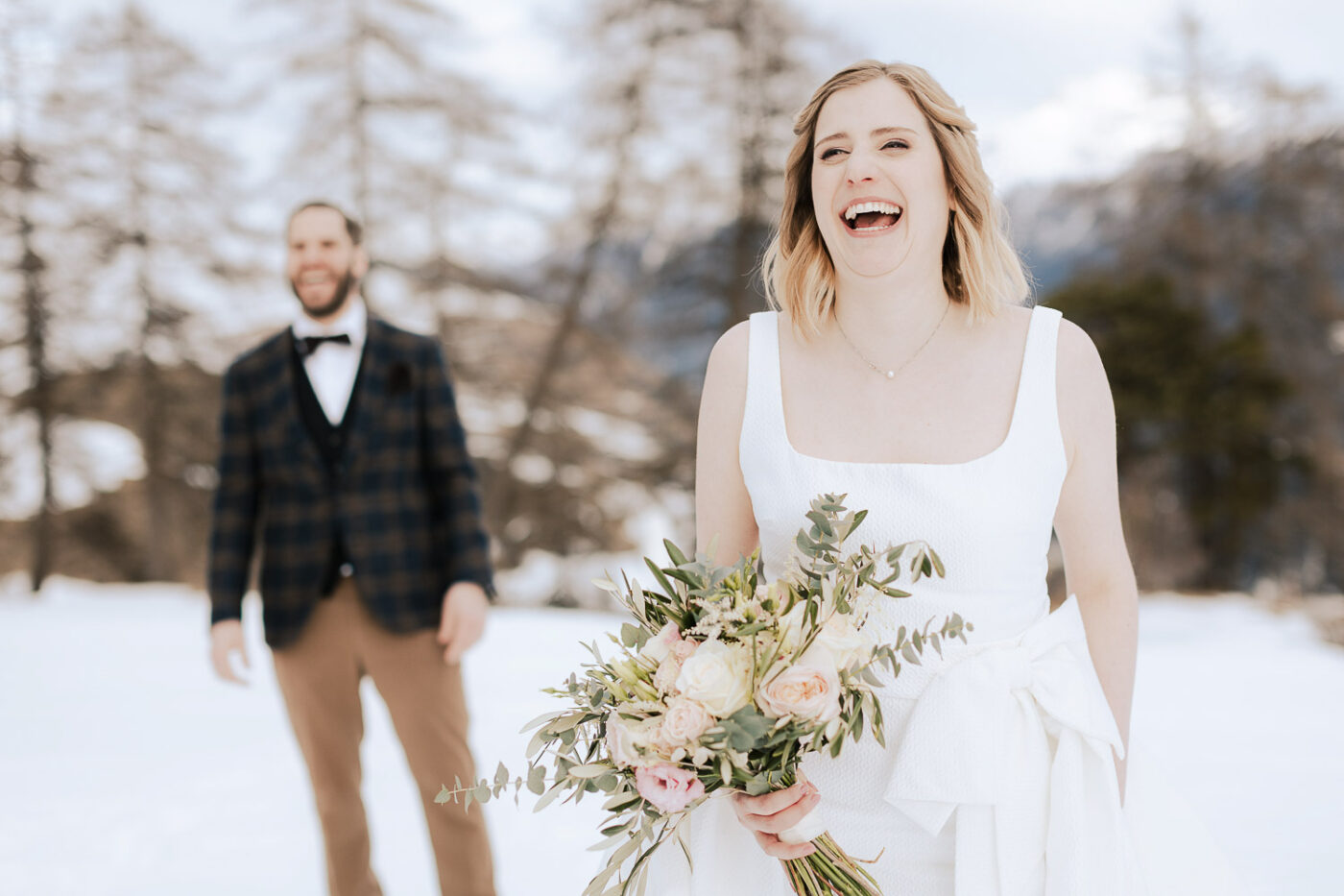 Lächelnde Braut mit Blumenstrauß im Schnee