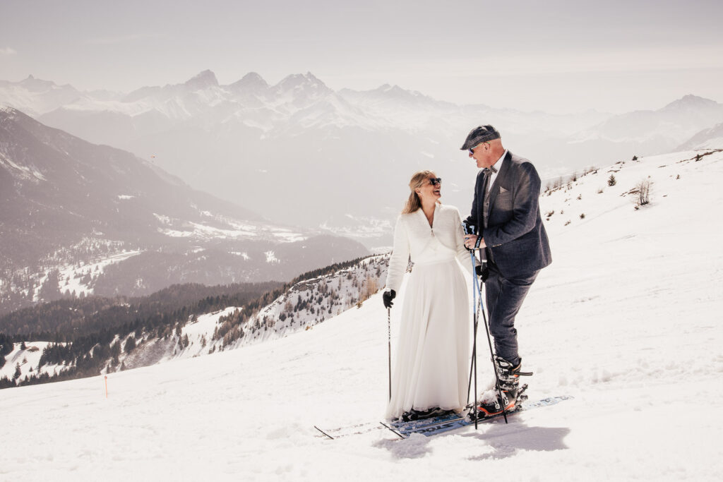 Hochzeitspaar auf Skiern bei einer Winterhochzeit in den Bergen