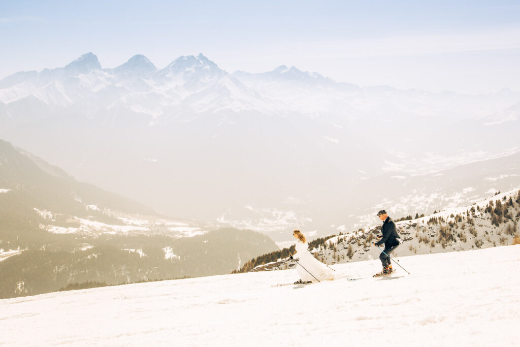 Hochzeitspaar beim Skifahren in den Alpen