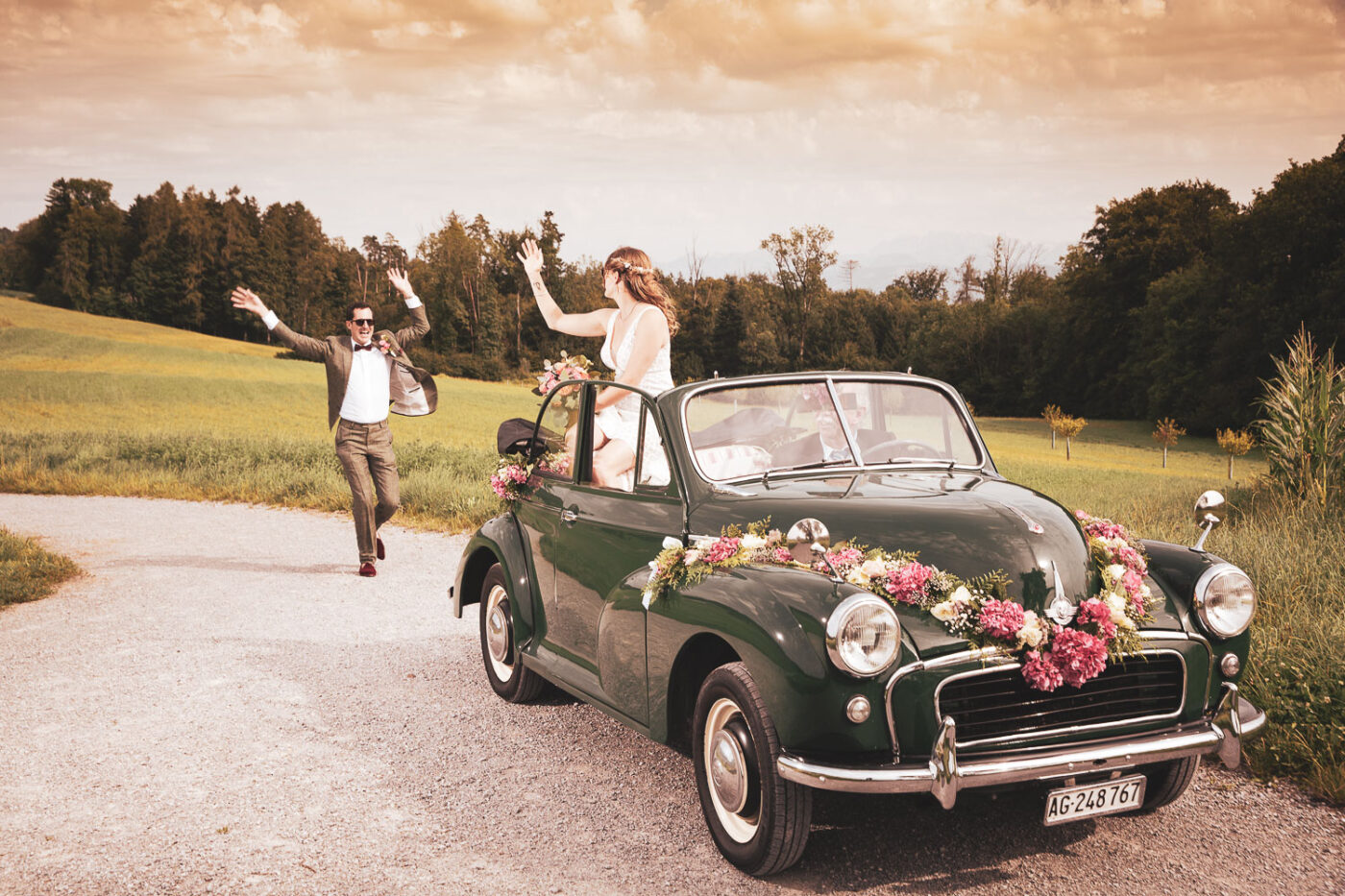 Hochzeitspaar mit Oldtimer auf einer ländlichen Straße