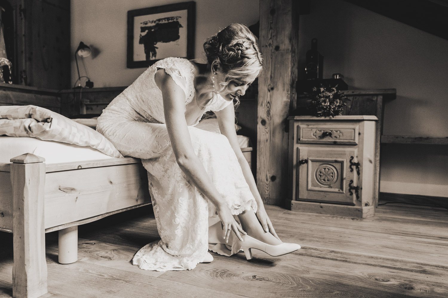 Braut zieht ihre Hochzeitsschuhe an im Hotel Bellavista im Engadin, festgehalten von Hochzeitsfotograf Adrian Flütsch.