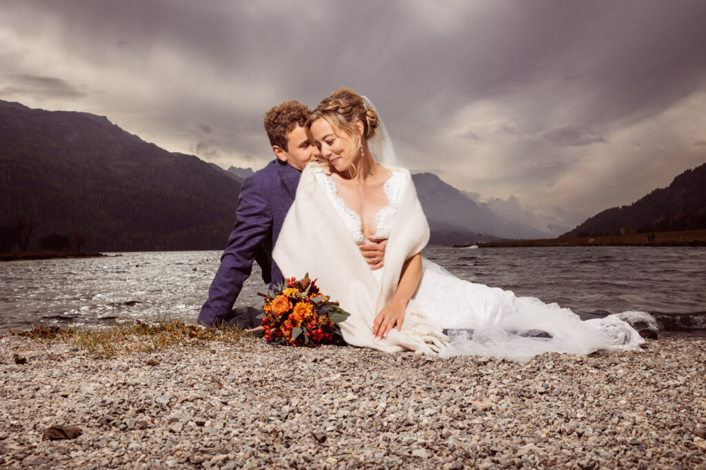 Romantisches Brautpaar am See im Engadin, eingefangen von Hochzeitsfotograf Adrian Flütsch.