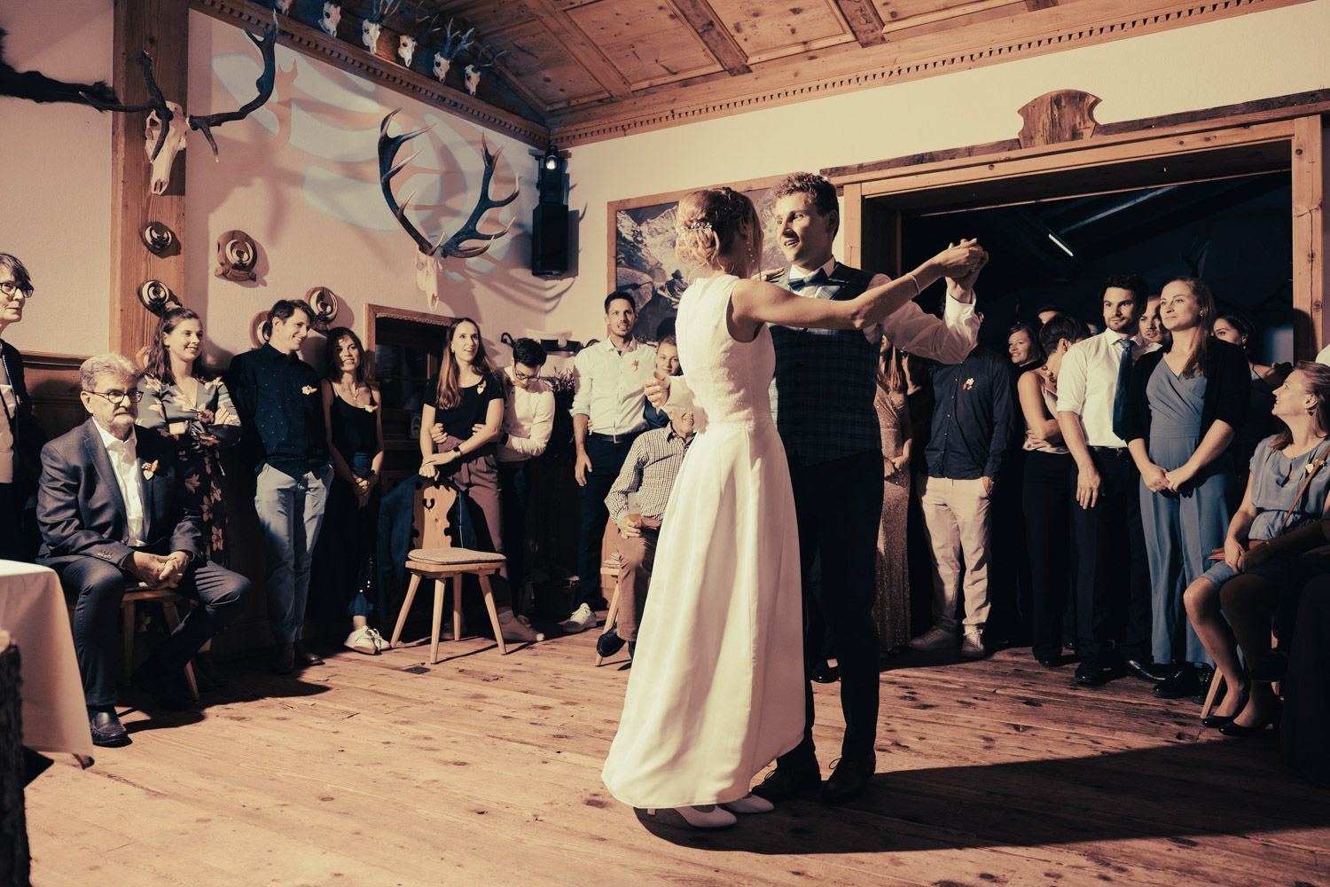 Brautpaar beim Hochzeitstanz im Hotel Bellavista, umgeben von Gästen, eingefangen von Hochzeitsfotograf Adrian Flütsch.