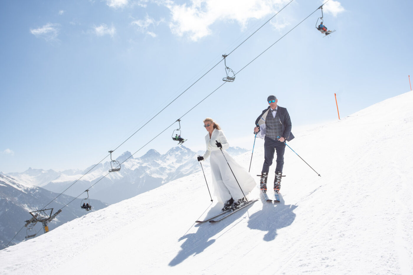 Brautpaar fährt auf Skiern unter der Sesselbahn Scalottas im Skigebiet Lenzerheide