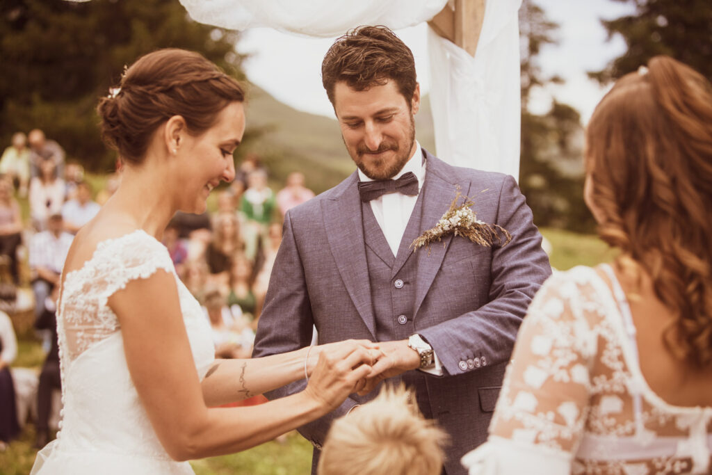 Brautpaar beim Ringtausch während einer Alphochzeit in Lenzerheide, festgehalten von Hochzeitsfotograf Adrian Flütsch.