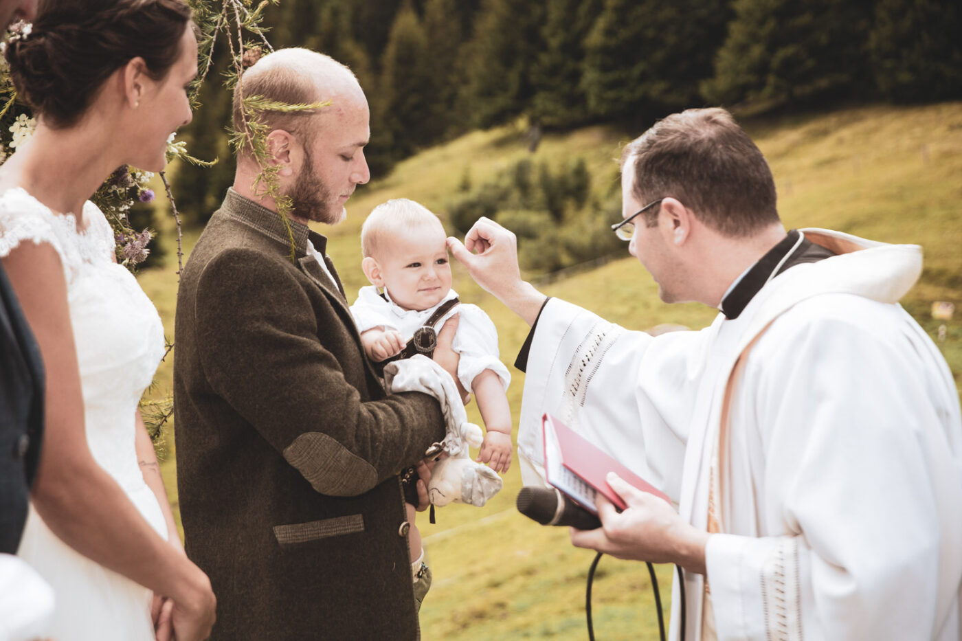 Taufe des Sohnes des Brautpaares während einer Alphochzeit in Lenzerheide, festgehalten von Hochzeitsfotograf Adrian Flütsch.