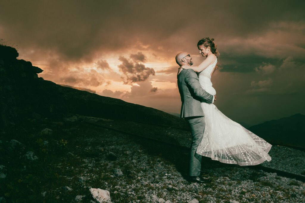 Brautpaar vor dramatischem Himmel auf dem Chäserrugg im Toggenburg, eingefangen vom renommierten Hochzeitsfotografen Adrian Flütsch