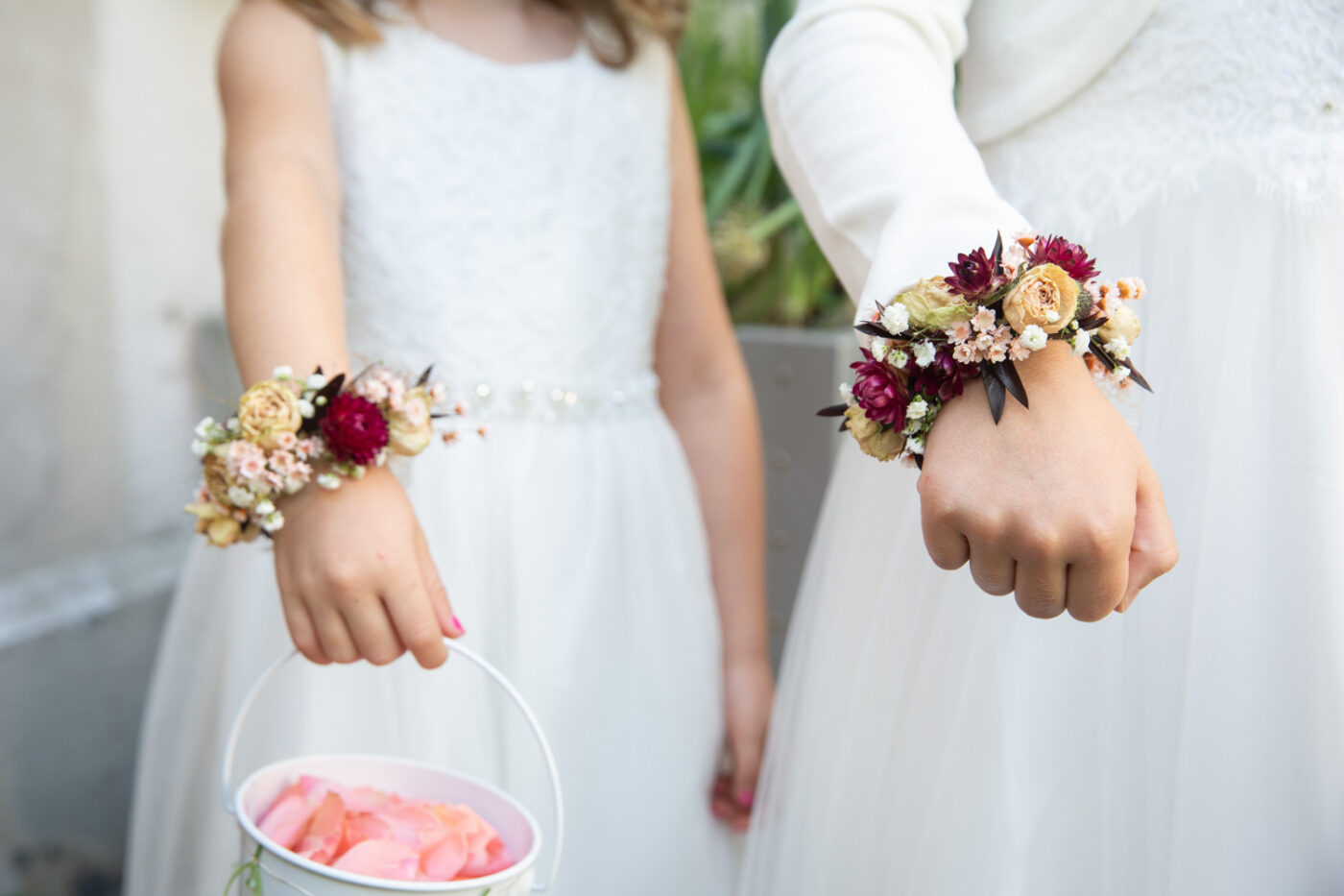 Blumenarmbänder der Blumenmädchen bei einer Hochzeit im Schloss Reichenau – natürliche Momentaufnahmen von Hochzeitsfotograf Adrian Flütsch.