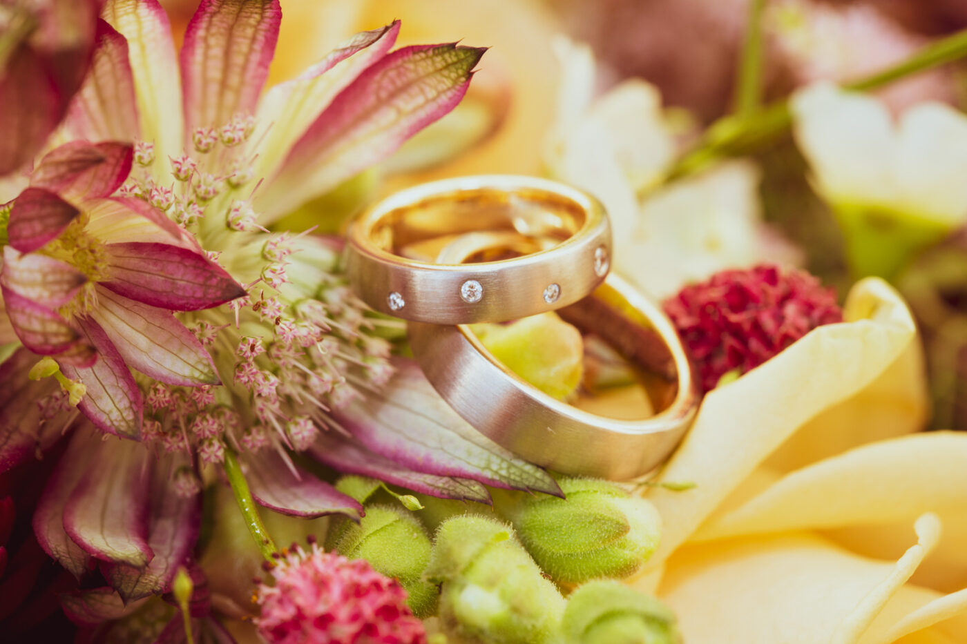 Detailaufnahme von Eheringen auf Hochzeitsblumen im Schloss Reichenau – natürliche Momentaufnahme von Hochzeitsfotograf Adrian Flütsch.