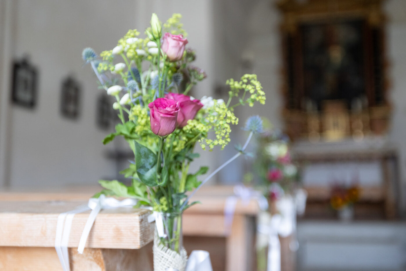 Detailaufnahme eines Blumenarrangements in der Kapelle Son Roc auf der Alp Flix, während einer Hochzeit – Hochzeitsfotograf Adrian Flütsch.