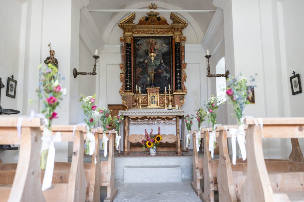 Innenansicht der Kapelle Son Roc auf der Alp Flix, liebevoll geschmückt für eine Hochzeit – Hochzeitsfotograf Adrian Flütsch.