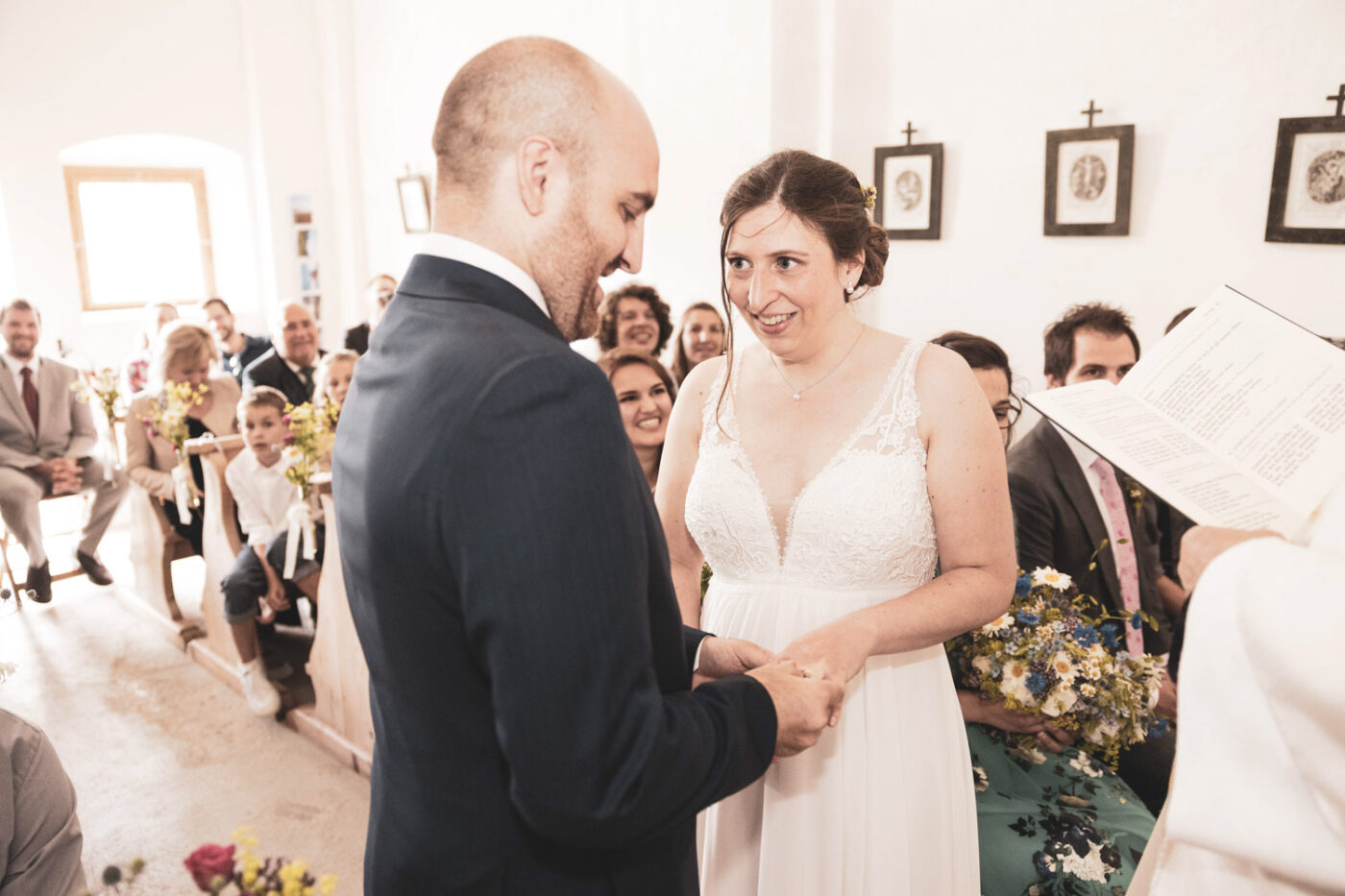 Braut und Bräutigam während der Trauung in der Kapelle auf der Alp Flix, festgehalten von Hochzeitsfotograf Adrian Flütsch.