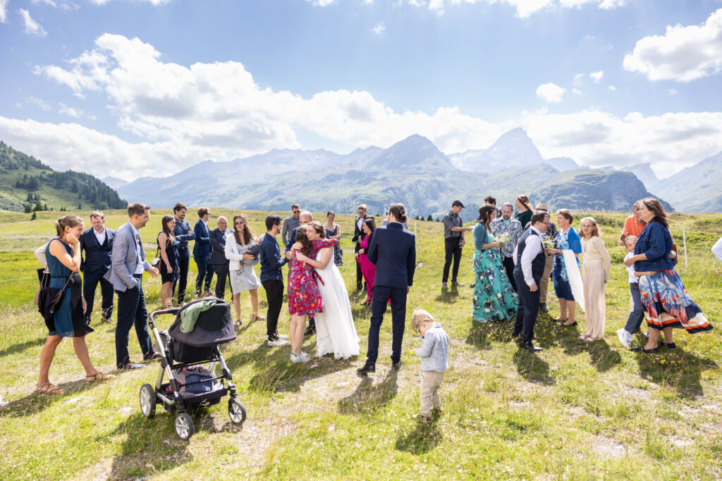 Hochzeitsgäste bei der Feier auf der Alp Flix mit beeindruckendem Bergpanorama, fotografiert von Hochzeitsfotograf Adrian Flütsch.