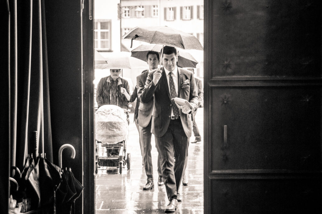 Hochzeitsgäste mit Regenschirmen bei betreten der Kathedrale in Chur - Fotograf Adrian Flütsch