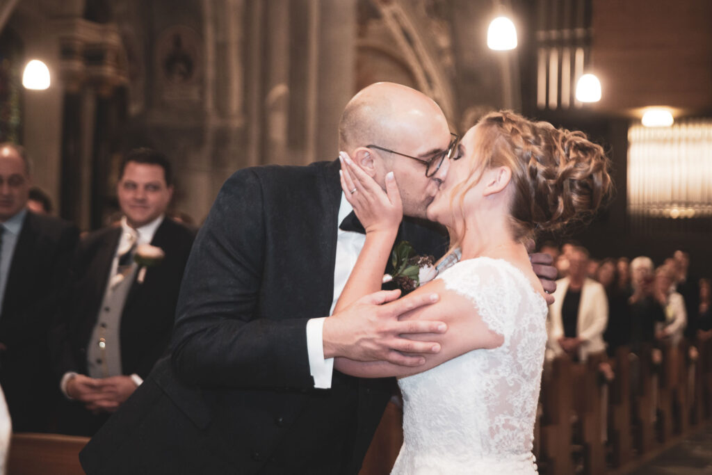 Der erste Kuss des Brautpaares in der Kirche - Fotograf Adrian Flütsch