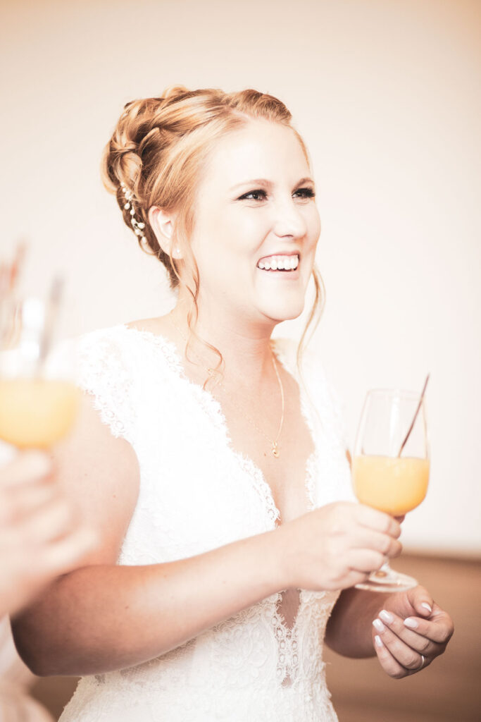 Strahlende Braut mit einem Glas Orangensaft - Hochzeitsfotograf Adrian Flütsch